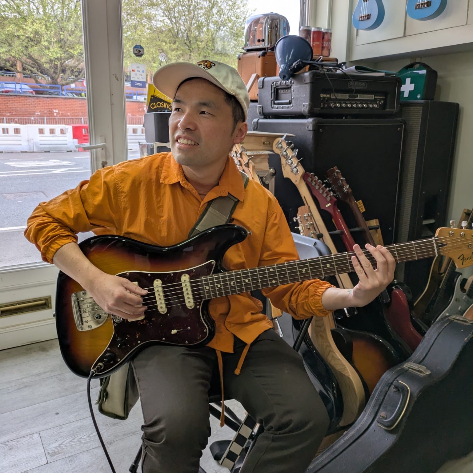 Photo of me, playing a Fender Bass VI hybrid guitar bass in a music shop